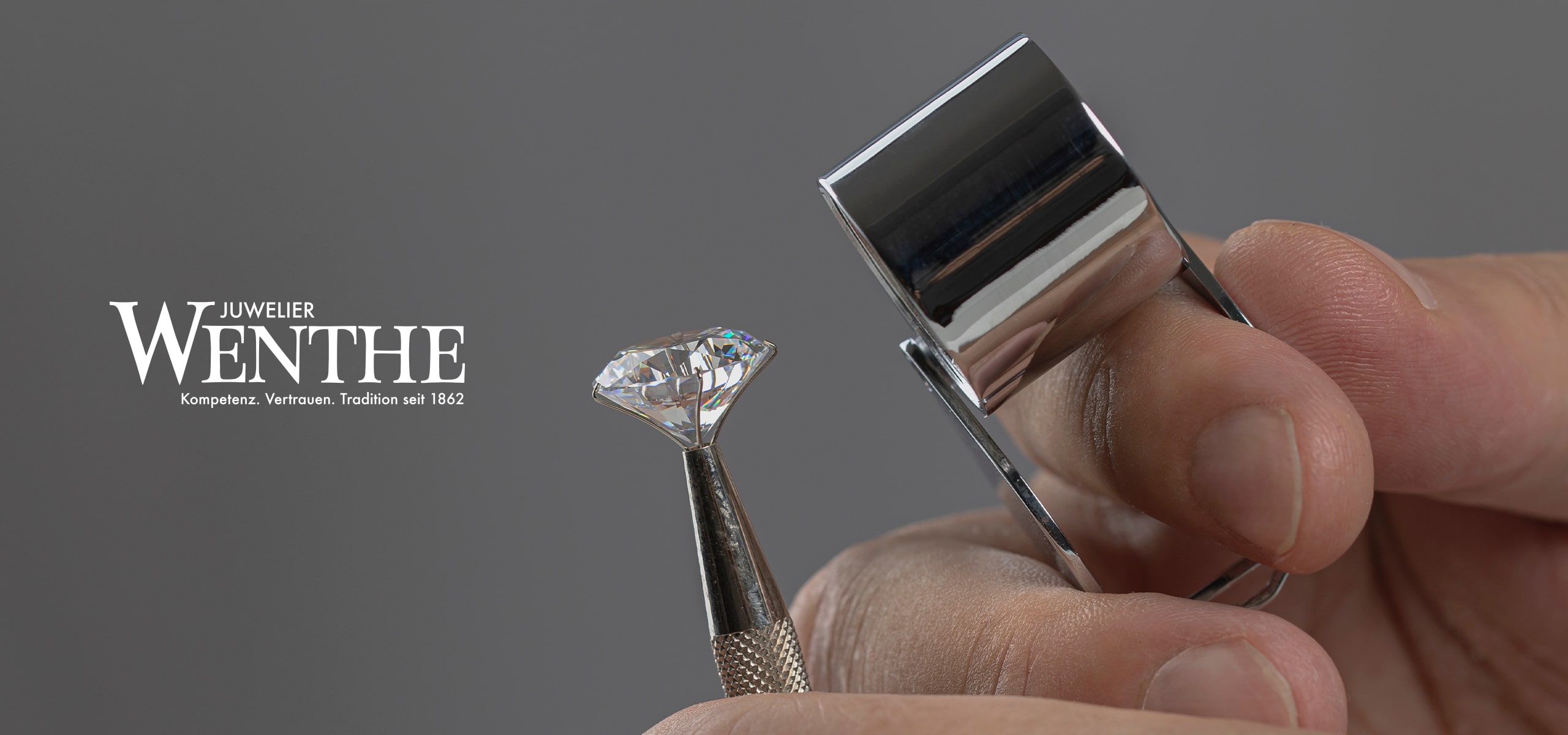 © Juwelier Wenthe Eine Hand hält einen Diamanten mit einer Pinzette, während eine andere Hand eine Juwelierlupe benutzt, um den Edelstein zu untersuchen. Der Text "Juwelier Wenthe" und ein Slogan sind auf der linken Seite des Bildes zu sehen.