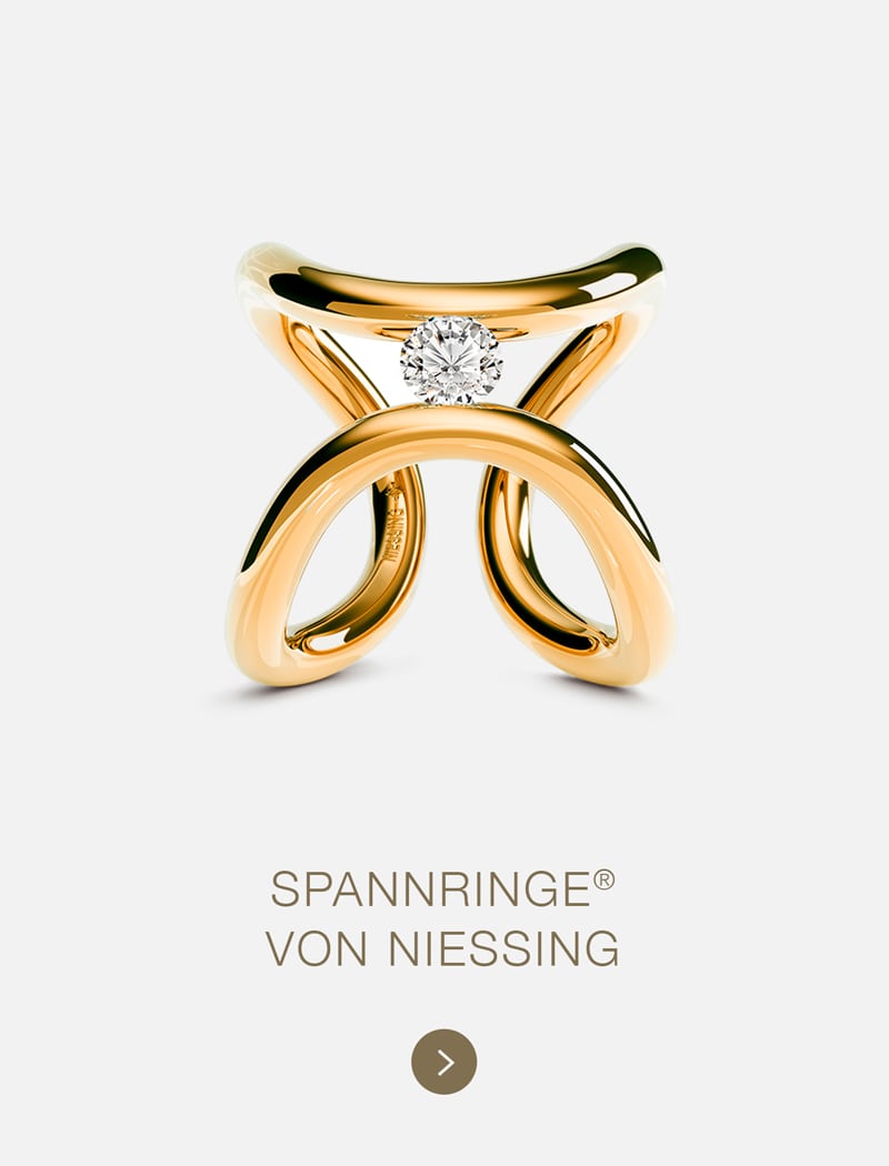 Ein goldener Niessing Ring mit einem modernen, offenen Design hält einen einzelnen Diamanten in der Mitte. Der Hintergrund ist weiß und der Text darunter lautet "Spannringe® von Niessing".