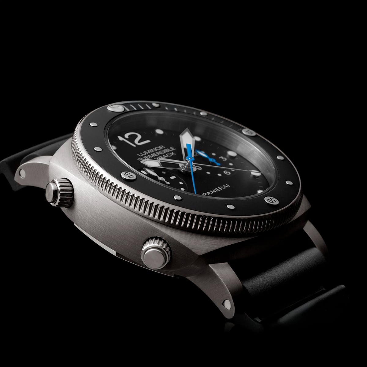 2025 © Panerai Nahaufnahme einer luxuriösen Panerai-Armbanduhr mit schwarzem Zifferblatt, silberner Lünette und blauen Hervorhebungen auf den Zeigern, die an einem schwarzen Armband vor einem dunklen Hintergrund präsentiert wird.