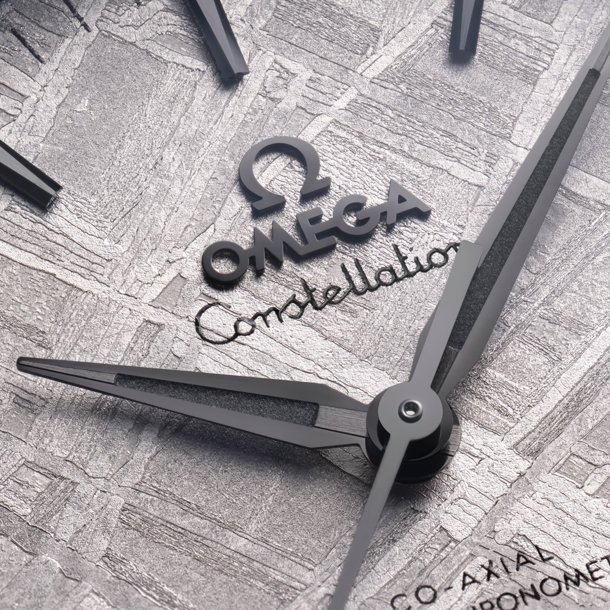 2025 © OMEGA Nahaufnahme des Ziffernblatts einer Omega Constellation mit schwarzen Zeigern, "OMEGA"- und "Constellation"-Text und einem strukturierten Metallhintergrund. Das detaillierte Design unterstreicht die charakteristische Handwerkskunst der Constellation-Kollektion.