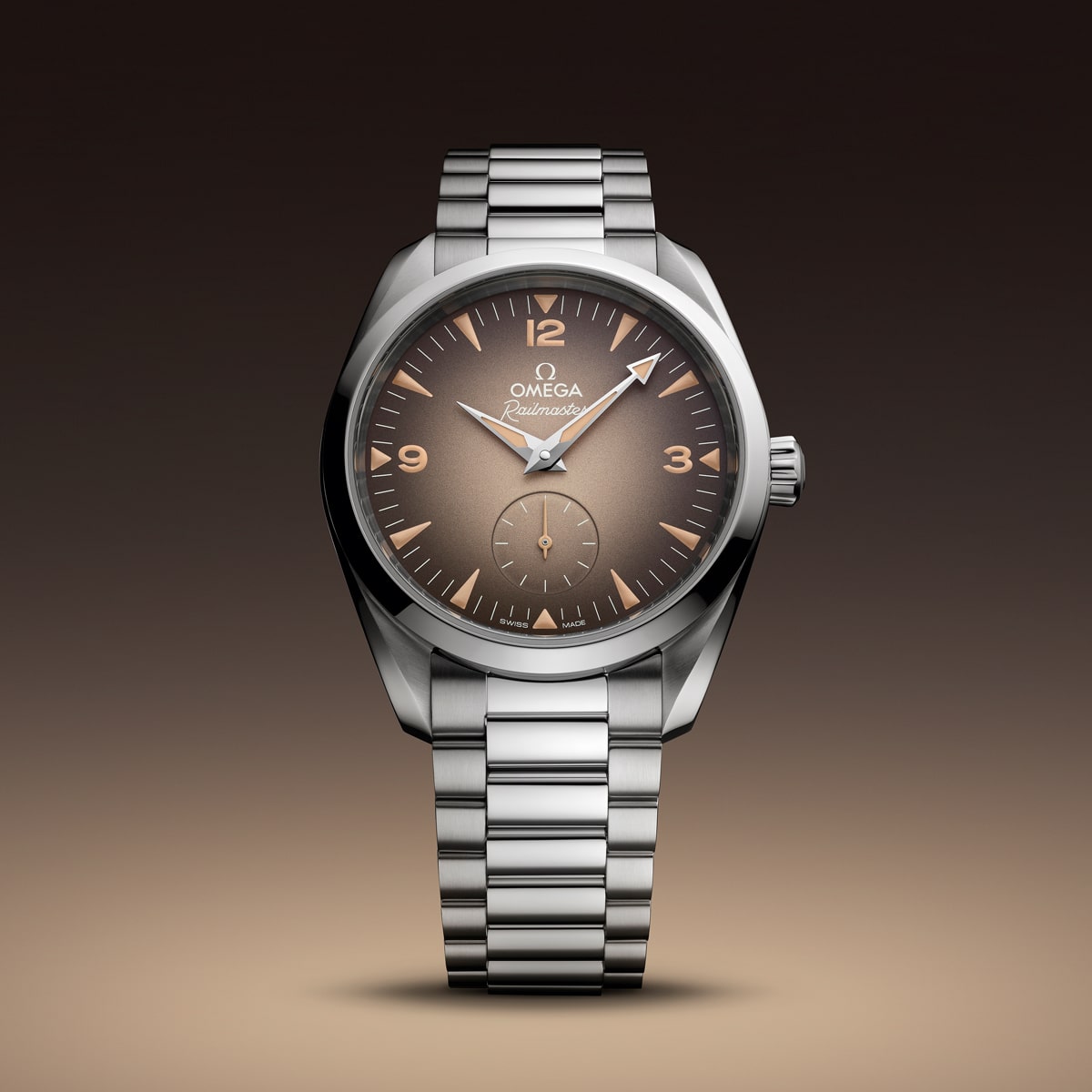 2025 © OMEGA Eine Omega Seamaster Heritage Armbanduhr aus Edelstahl mit einem braunen Zifferblatt mit Farbverlauf, silbernen Indexen, Leuchtzeigern und einem Gliederarmband aus Metall, dargestellt vor einem braunen Hintergrund mit Farbverlauf.