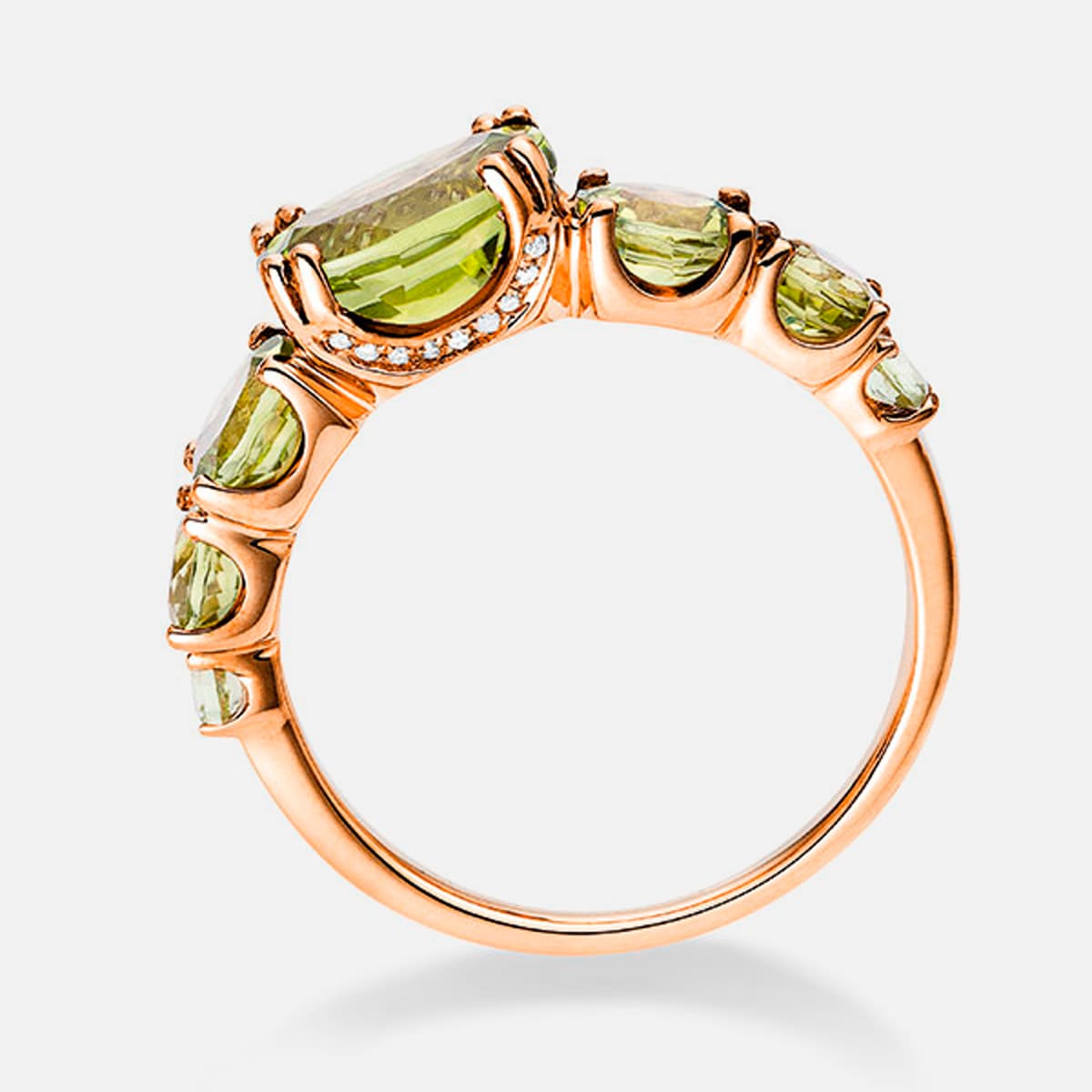 2025 © Diamond Group Ein Diamantring aus Roségold mit einem großen, rechteckigen, hellgrünen Edelstein in der Mitte, flankiert von kleineren, passenden grünen Steinen entlang des aufwendig gestalteten Bandes.