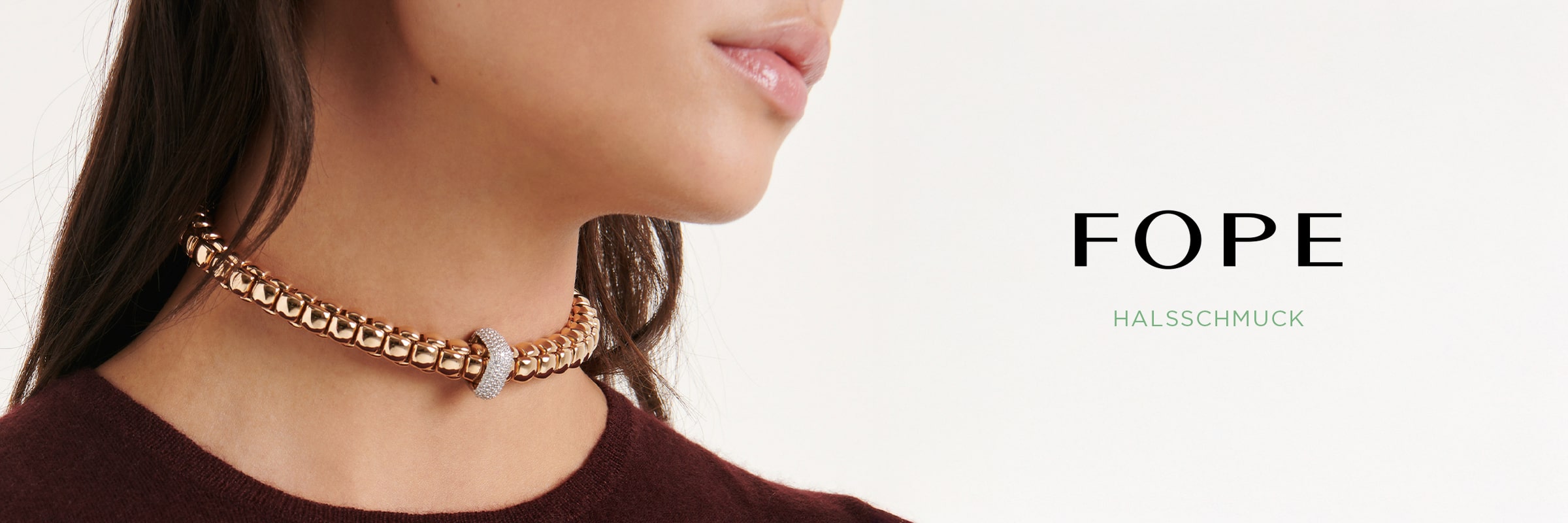 2025 © FOPE Nahaufnahme einer Frau, die ein goldenes FOPE Halsschmuck-Halsband mit Diamantenakzenten trägt. Der Hintergrund ist weiß, und neben ihr erscheint der Text "FOPE HALSSCHMUCK".