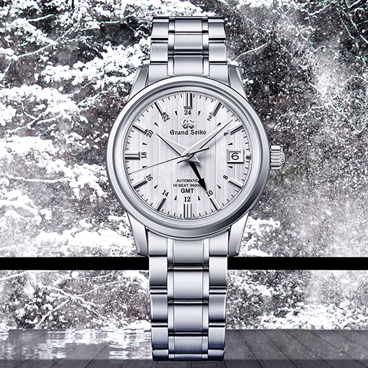 2025 © GRAND SEIKO Eine silberne Grand Seiko Elegance Armbanduhr mit strukturiertem weißem Zifferblatt steht aufrecht vor einer verschneiten, winterlichen Waldszene, durch das Fenster dahinter sind schneebedeckte Bäume zu sehen.