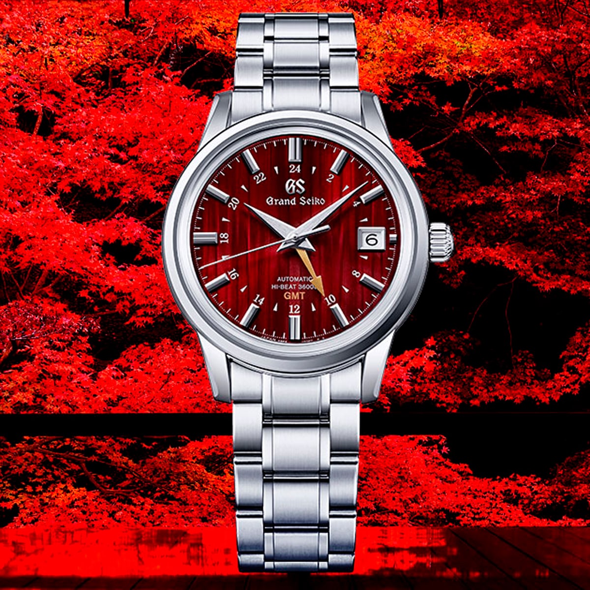 2025 © GRAND SEIKO Eine Grand Seiko Elegance Armbanduhr mit rotem, strukturiertem Zifferblatt, silbernen Indexen und einem Edelstahlarmband wird durch leuchtend rote Herbstblätter in Szene gesetzt.