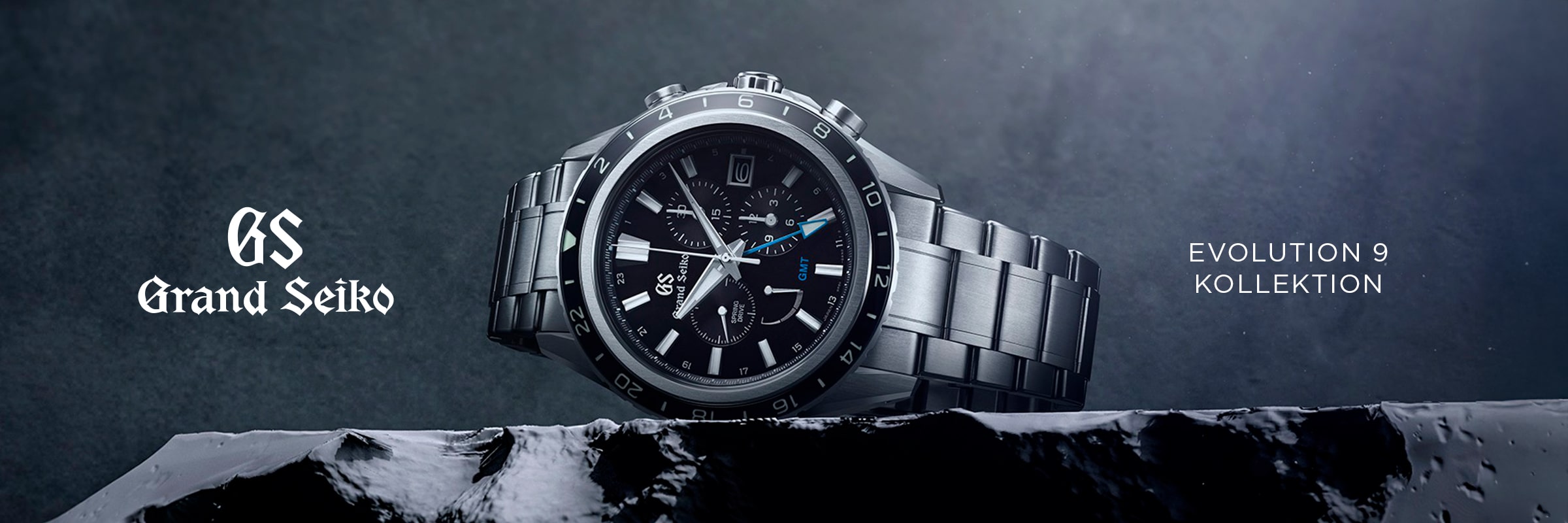 2025 © GRAND SEIKO Eine Grand Seiko Evolution 9 Luxusarmbanduhr mit schwarzem Zifferblatt und Metallband ist auf einer felsigen Oberfläche abgebildet. Der Text lautet "GS Grand Seiko" und "EVOLUTION 9 KOLLEKTION" auf einem dunklen, strukturierten Hintergrund.