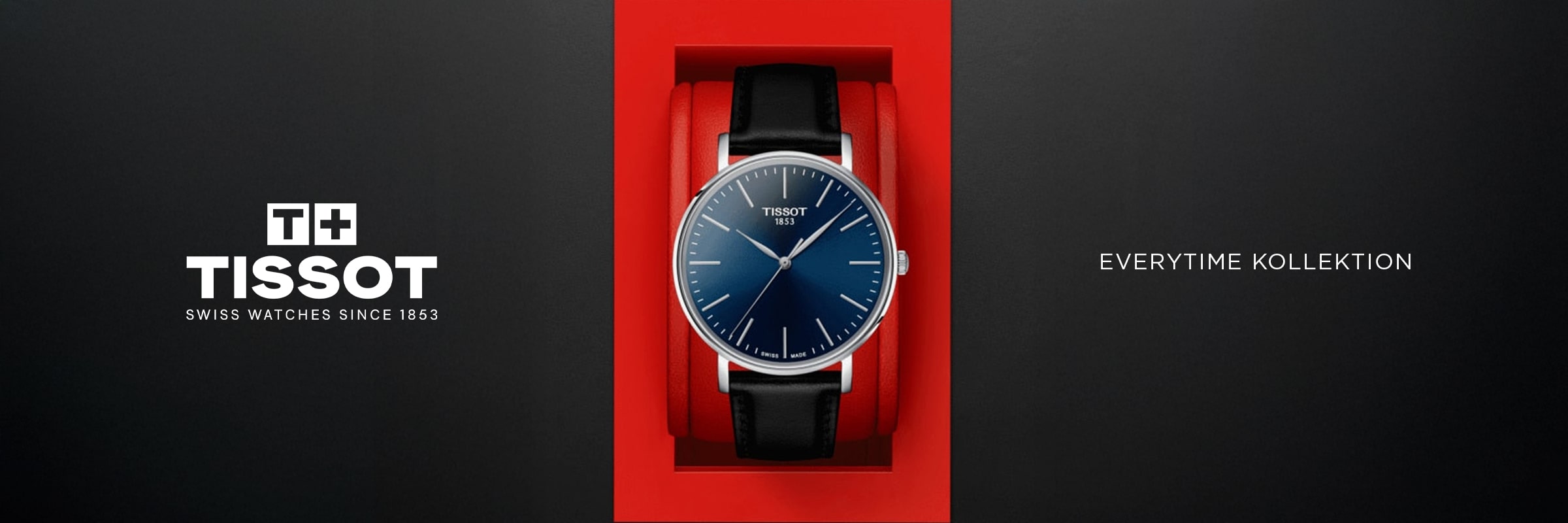 2025 © TISSOT Eine Tissot Everytime-Armbanduhr mit schwarzem Lederarmband und blauem Zifferblatt wird in einer roten Schachtel präsentiert. Das Tissot-Logo und der Text "Swiss Watches Since 1853" und "Everytime Kollektion" erscheinen auf einem schwarzen Hintergrund.