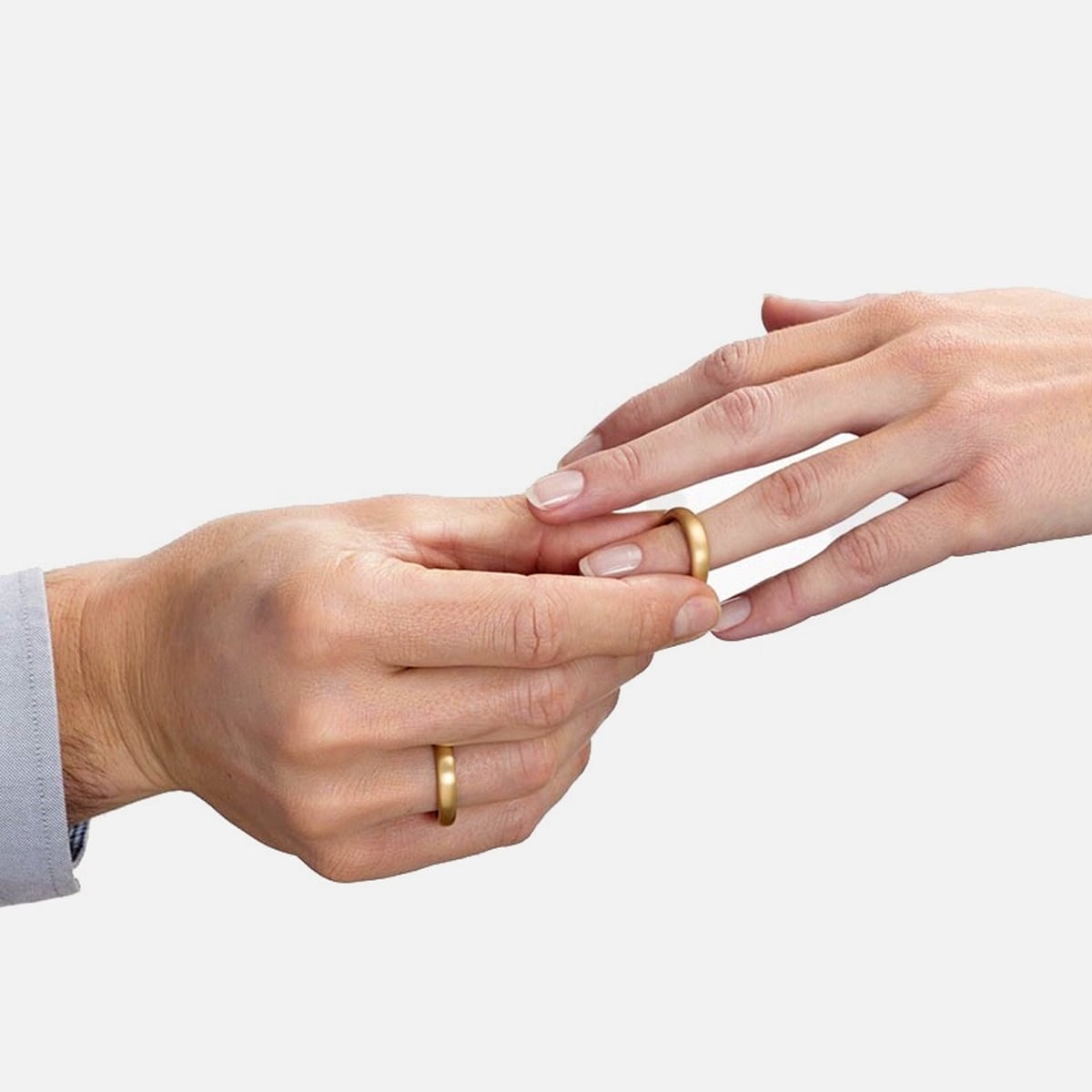 2025 © Niessing Eine Person steckt während einer Trauung einen Goldring an den Finger einer anderen Person. Beide haben helle Haut, und derjenige, der den Ring ansteckt, trägt ebenfalls einen Goldring. Der schlichte weiße Hintergrund lenkt die Aufmerksamkeit auf diesen besonderen Moment.