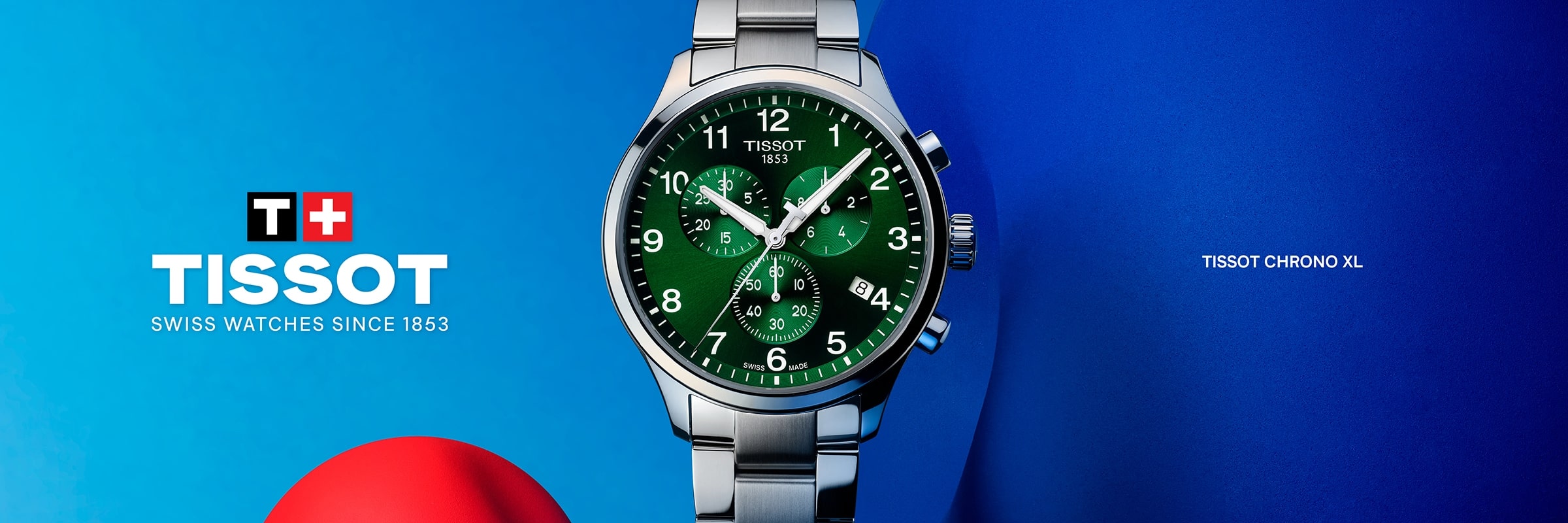 2025 © TISSOT Eine Tissot XL Chrono Armbanduhr mit grünem Zifferblatt und silbernem Metallband wird vor einem leuchtend blauen und roten Hintergrund mit dem Tissot-Logo und dem Slogan "Swiss Watches Since 1853" präsentiert.