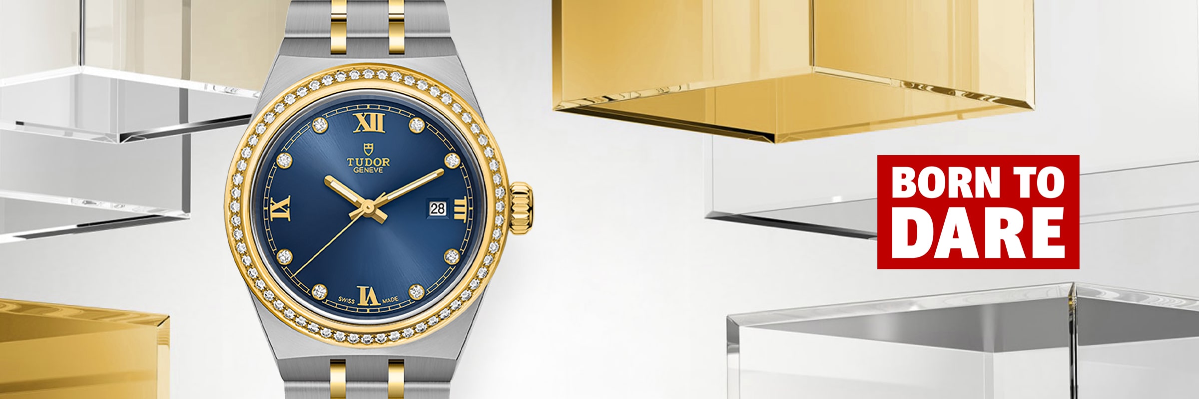 2026 © TUDOR Eine luxuriöse Tudor Royal Armbanduhr mit blauem Zifferblatt, goldenen Akzenten und einer diamantenen Lünette wird zwischen transparenten und goldenen geometrischen Blöcken präsentiert. Rechts daneben steht in einer rot-weißen Box "BORN TO DARE".