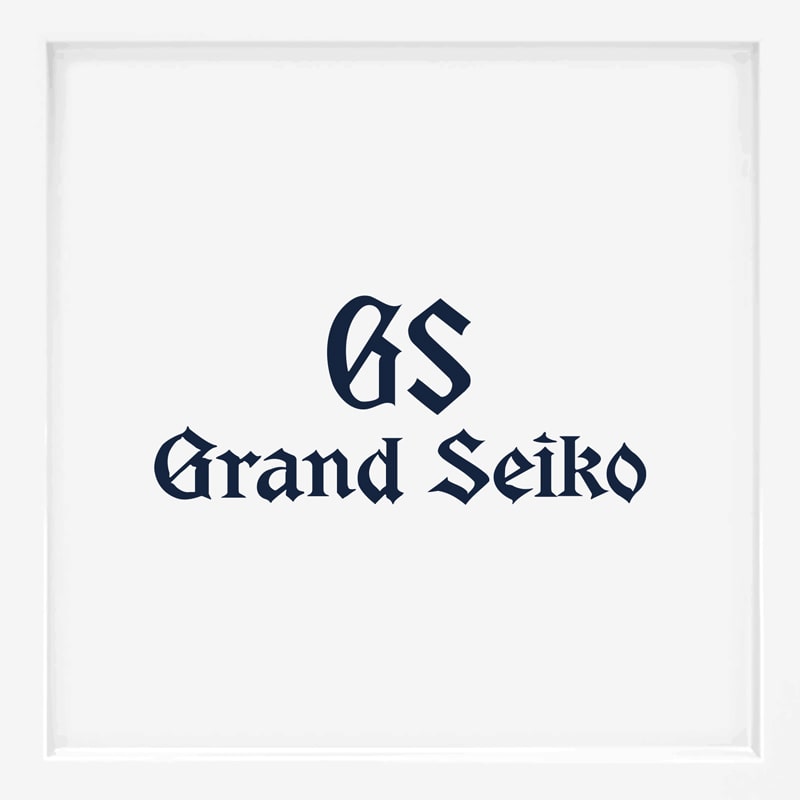 Das Bild zeigt das Grand Seiko-Logo in dunkelblauer, gotischer Schrift auf einem schlichten weißen Hintergrund und unterstreicht damit die Eleganz, die man oft mit Top-Uhrenmarken verbindet.