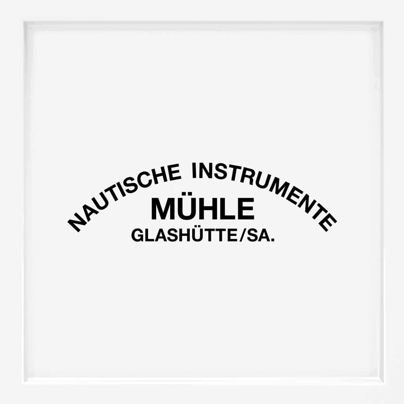 Der schwarze Text auf weißem Grund lautet "NAUTISCHE INSTRUMENTE MÜHLE GLASHÜTTE/SA." in Bogenform, wobei "MÜHLE" in größeren, fetten Buchstaben diese renommierte Uhrenmarke in der Mitte hervorhebt.