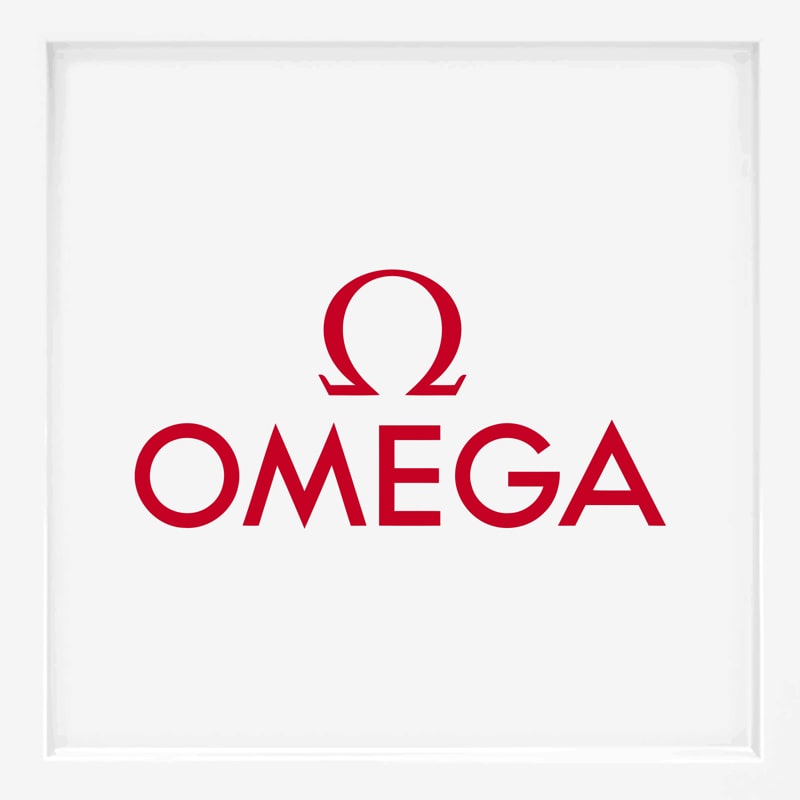 Das Bild zeigt das OMEGA-Logo mit dem griechischen Buchstaben Omega (Ω) über dem Wort "OMEGA", beides in fetter roter Schrift auf weißem Hintergrund, das eine der renommiertesten Uhrenmarken der Welt darstellt.