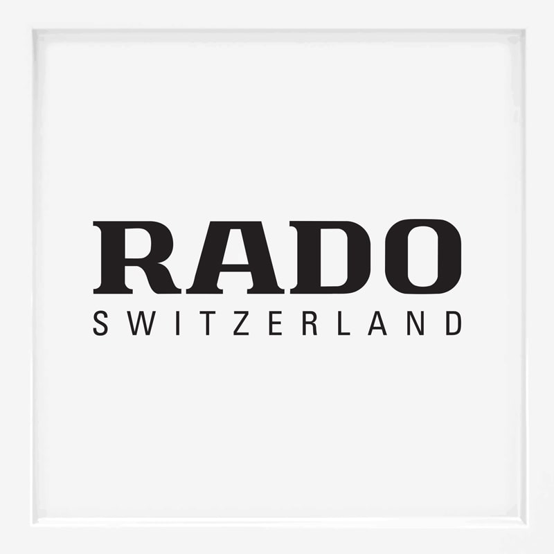 Das Bild zeigt das Logo von RADO Schweiz, einem bekannten Namen unter den Uhrenmarken, mit "RADO" in fetten schwarzen Buchstaben über "SWITZERLAND" in kleineren schwarzen Buchstaben auf weißem Hintergrund.