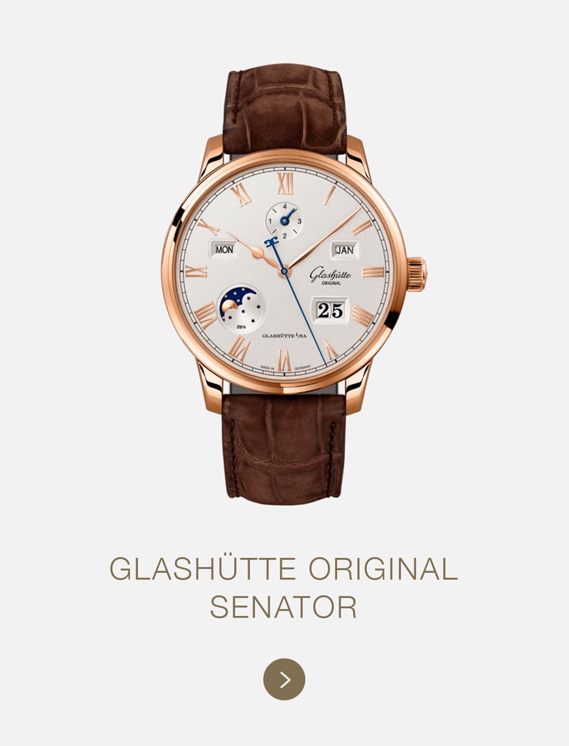Eine Glashütte Original Senator Uhr mit braunem Lederarmband, roségoldenem Gehäuse, silbernem Zifferblatt mit römischen Ziffern und mehreren Hilfszifferblättern, die Tag, Monat, Mondphase und Datum anzeigen.