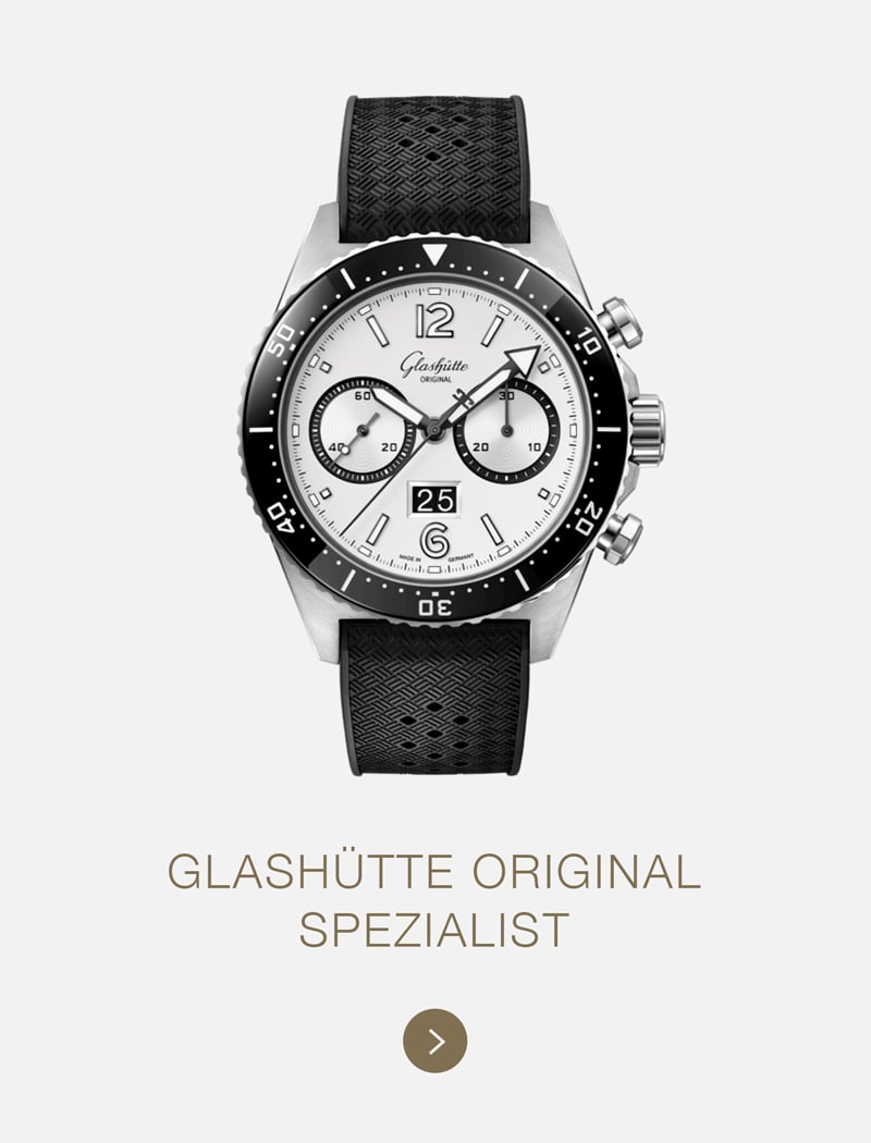 Eine Glashütte Original Specialist Armbanduhr mit schwarzem Armband, weißem Zifferblatt und schwarzer Lünette mit zwei Hilfszifferblättern ist hochkant über dem Text GLASHÜTTE ORIGINAL SPEZIALIST" auf hellem Grund angebracht.