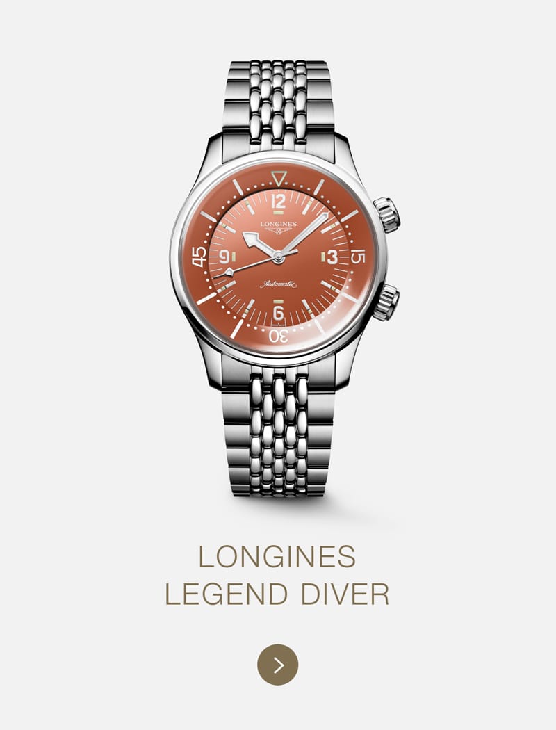 Eine silberne LONGINES Legend Diver Uhr mit einem runden, orangefarbenen Zifferblatt mit weißen Markierungen und einem Gliederarmband aus Metall auf einem schlichten hellen Hintergrund.