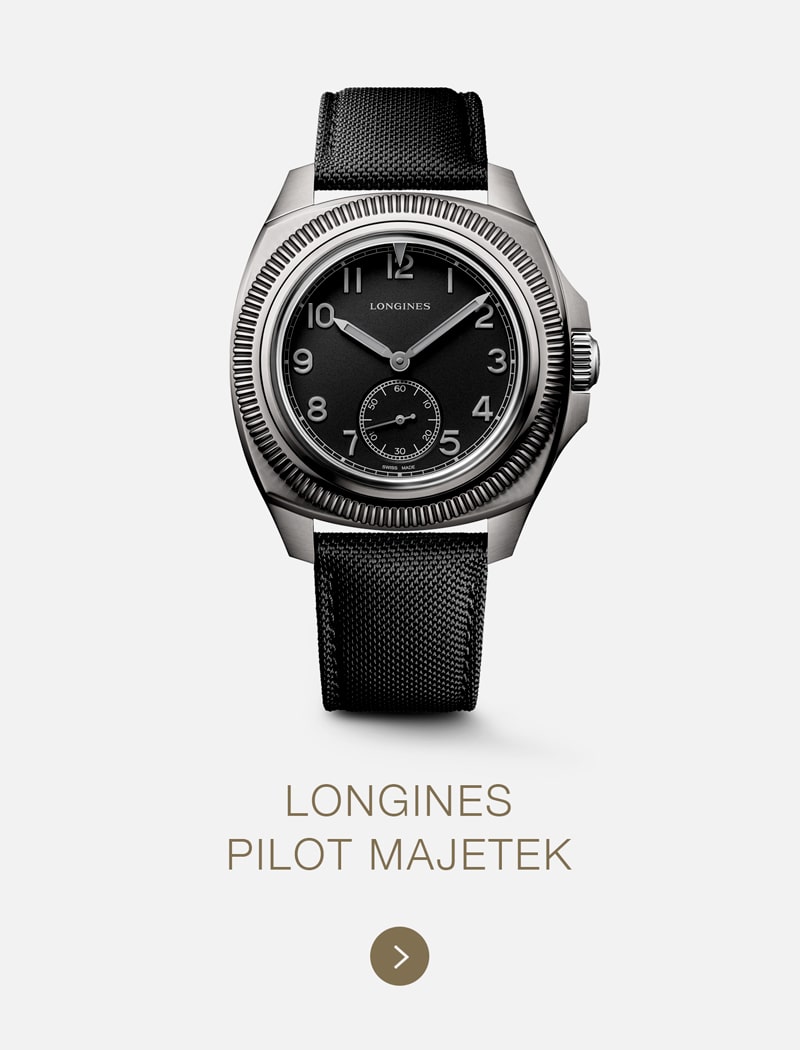 Eine LONGINES Pilot Majetek Armbanduhr mit schwarzem Zifferblatt, silbernem Gehäuse, arabischen Ziffern, kleiner Sekundenanzeige und schwarzem Stoffarmband wird vor einem hellen Hintergrund mit dem Text "LONGINES PILOT MAJETEK" darunter dargestellt.