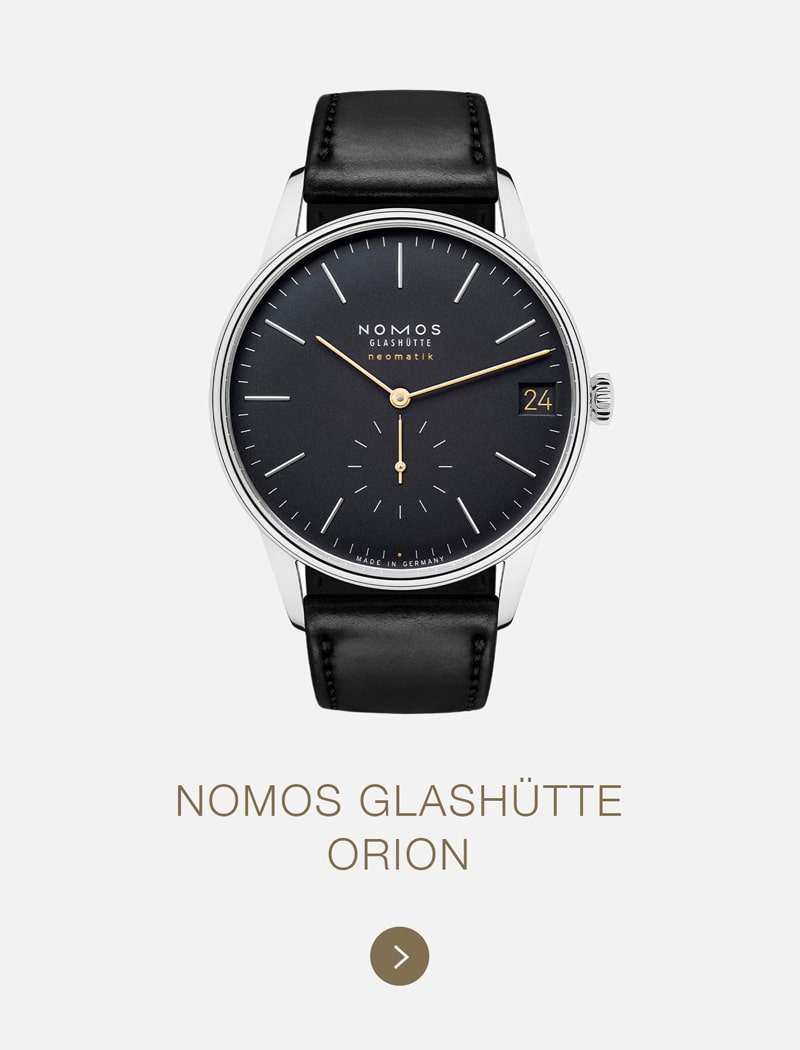 Eine NOMOS Glashütte Orion-Armbanduhr mit schwarzem Lederarmband, minimalistischem schwarzem Zifferblatt, silbernen Indexen und goldenen Akzenten steht auf einem hellgrauen Hintergrund und hebt die Modellbezeichnung NOMOS Glashütte hervor.