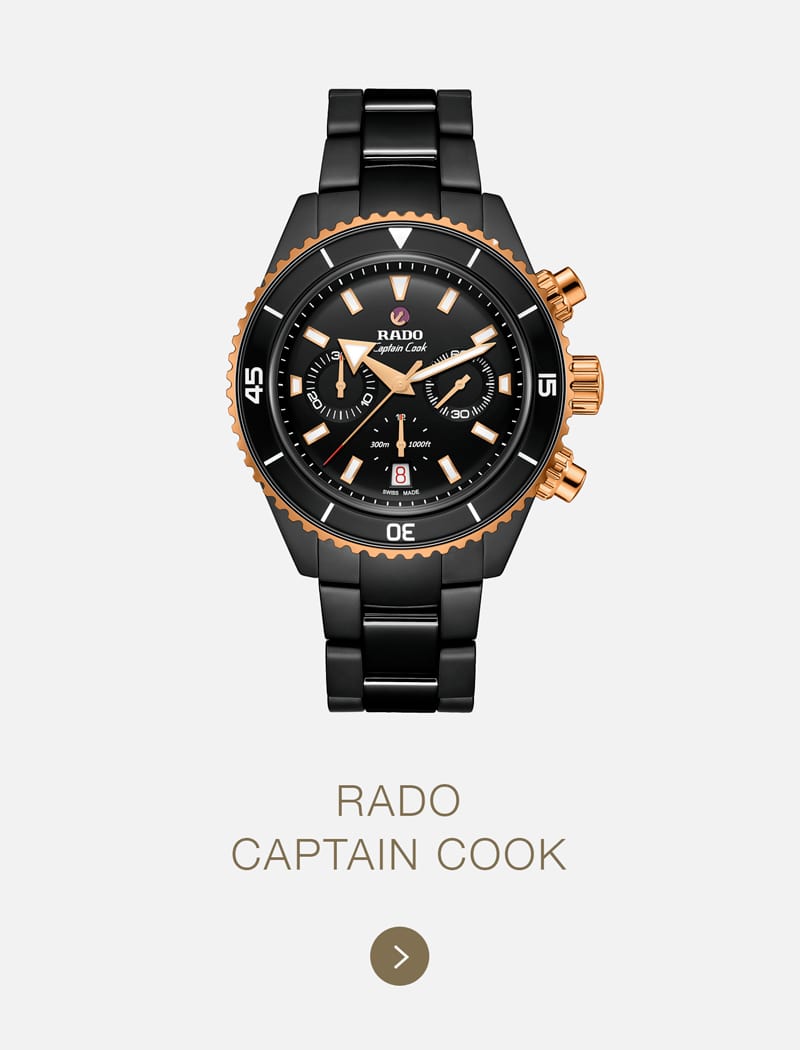 Die Rado Captain Cook Armbanduhr in schwarzem und roségoldenem Design mit schwarzem Keramikarmband, drei Hilfszifferblättern und auffälligen weißen Markierungen auf der Lünette wird elegant vor einem hellen Hintergrund präsentiert.