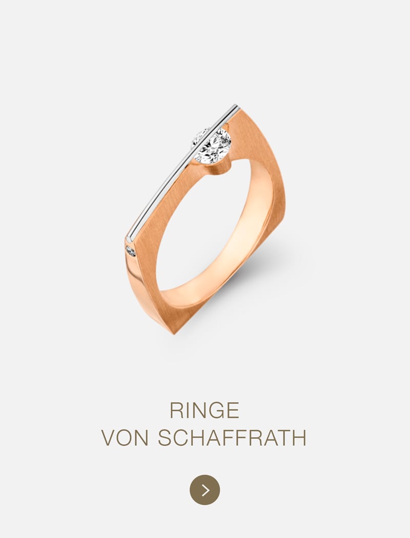 Ein moderner Goldring von Schaffrath mit einem quadratischen Design, das einen großen zentralen Diamanten und einen kleinen seitlichen Diamanten aufweist, wird über dem Text "RINGE VON SCHAFFRATH" auf hellem Hintergrund angezeigt.