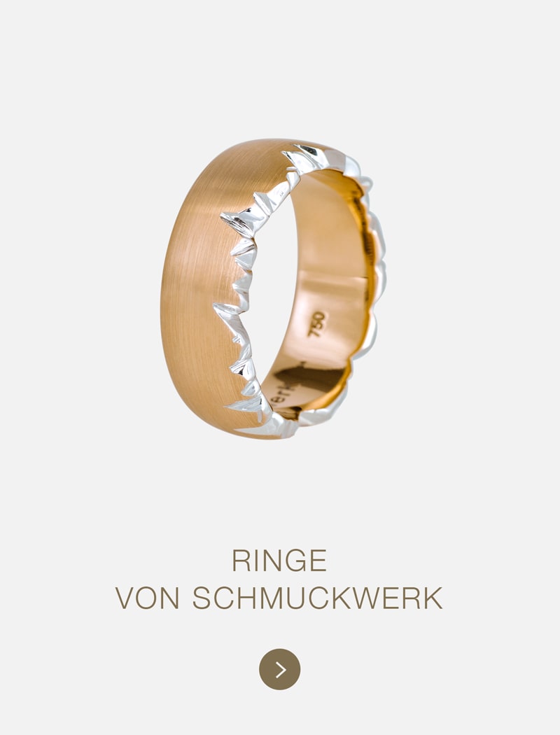 Ein goldener Ring mit einem gezackten, silbern umrandeten Muster entlang der Außenseite auf einem schlichten weißen Hintergrund. Der Text darunter lautet: "RINGE VON SCHMUCKWERK" - ein markantes Stück aus der unverwechselbaren Kollektion von Schmuckwerk.