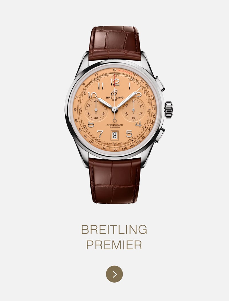 Eine Breitling Premier Uhr mit hellbraunem Lederarmband und lachsfarbenem Zifferblatt mit drei Hilfszifferblättern und silbernem Gehäuse auf weißem Hintergrund mit dem ikonischen Text "BREITLING PREMIER" darunter.