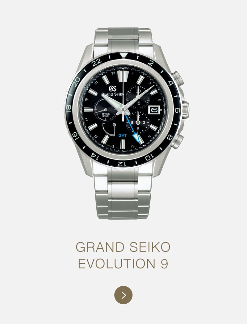 Eine Grand Seiko Evolution 9 Armbanduhr mit einem Edelstahlband, schwarzem Zifferblatt, mehreren Unterzifferblättern, Datumsanzeige und einer schwarzen Lünette. Der elegante Grand Seiko Zeitmesser ist über dem Text "Grand Seiko Evolution 9" zentriert.