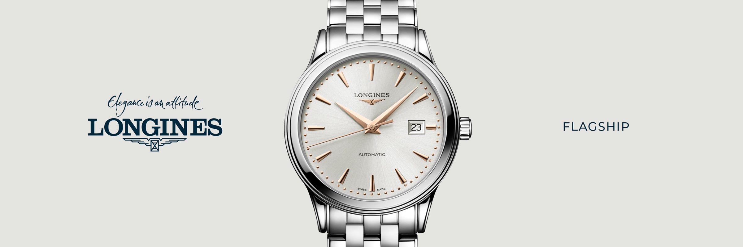 Eine silberne Longines Flagship Automatik-Armbanduhr mit weißem Zifferblatt, goldenen Indexen und einem Datumsfenster ist auf einem hellen Hintergrund zentriert. Das ikonische Flagship-Logo und der Slogan erscheinen auf der linken Seite.