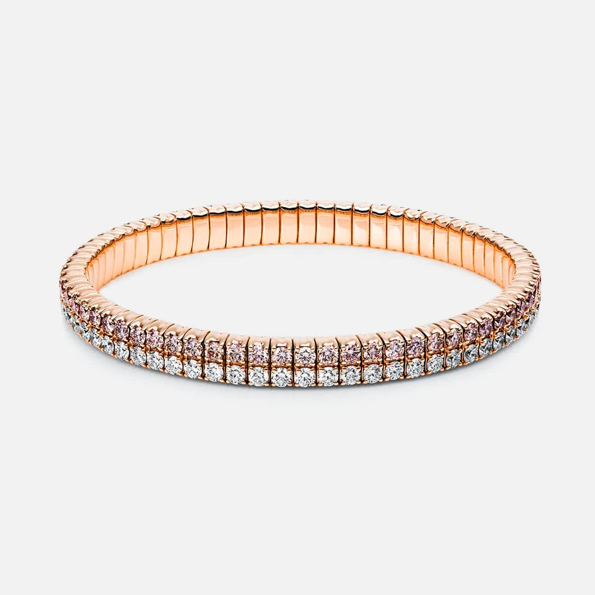 Ein Armschmuck-Armband aus Roségold von DiamondGroup mit zwei Reihen funkelnder weißer Edelsteine, die in einem flexiblen, segmentierten Band gefasst sind, das vor einem schlichten weißen Hintergrund steht.