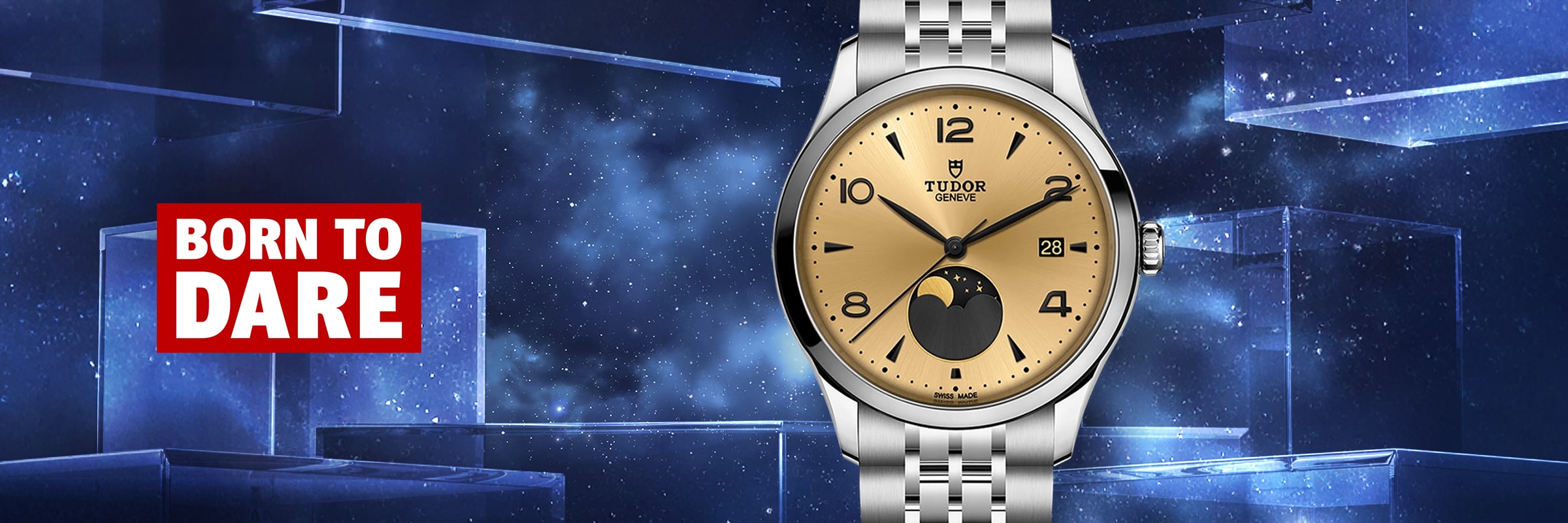 2025 © TUDOR Eine Tudor 1926 Armbanduhr mit goldenem Zifferblatt und Mondphasenanzeige ist vor einem kosmischen, sternenklaren blauen Hintergrund abgebildet. Auf der linken Seite steht in einem rot-weißen Kasten in fetter Schrift "BORN TO DARE".