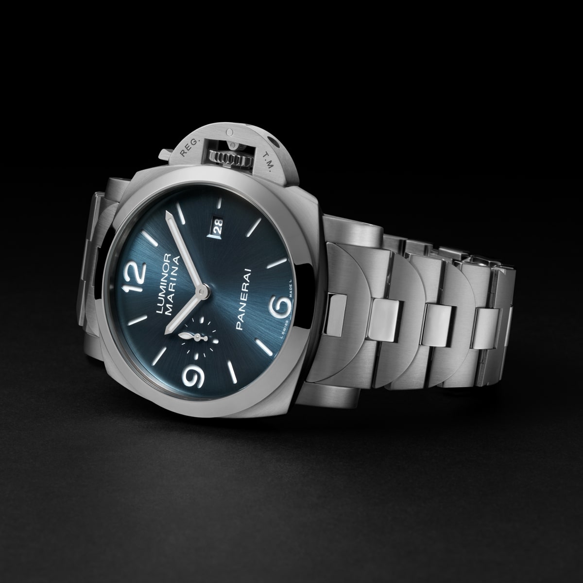 Eine Panerai Luminor Marina Armbanduhr aus Edelstahl aus der Panerai Luminor Kollektion mit blauem Sonnenschliff-Zifferblatt, silbernen Indexen, Datumsfenster und Metallgliederarmband, dargestellt auf einer dunklen Oberfläche.