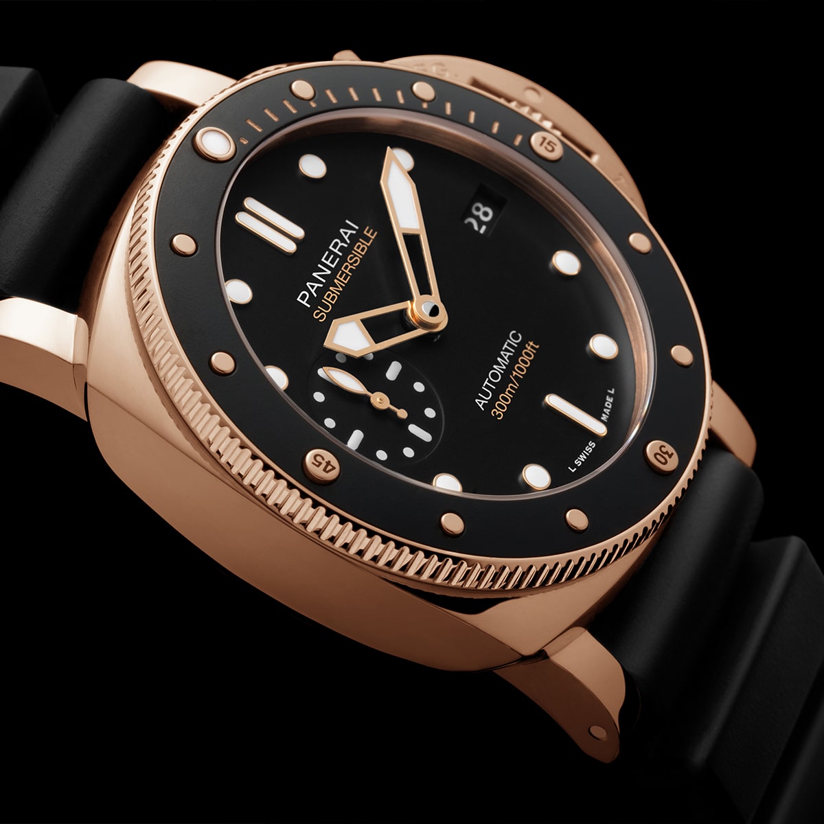 Nahaufnahme einer luxuriösen Panerai Submersible Uhr mit goldenem Gehäuse, schwarzer Lünette und schwarzem Kautschukarmband. Das Zifferblatt ist mit Leuchtmarkierungen, einem Datumsfenster und der Aufschrift "Automatic 300m/1000ft" versehen und damit der perfekte Begleiter für den Tauchgang.