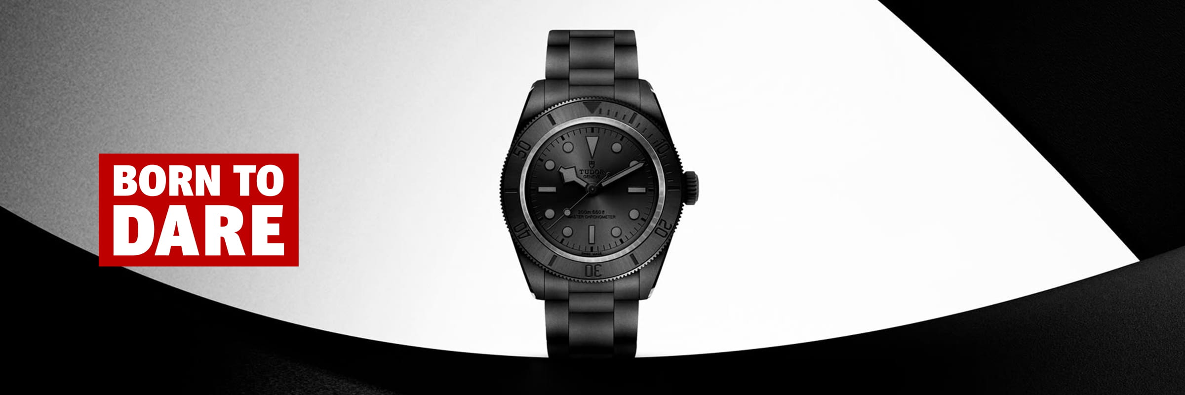 Eine Black Bay-Armbanduhr steht in der Mitte eines modernen abstrakten schwarz-weißen Hintergrunds. Auf der linken Seite enthält ein fetter roter Kasten den weißen und roten Text: "BORN TO DARE.
