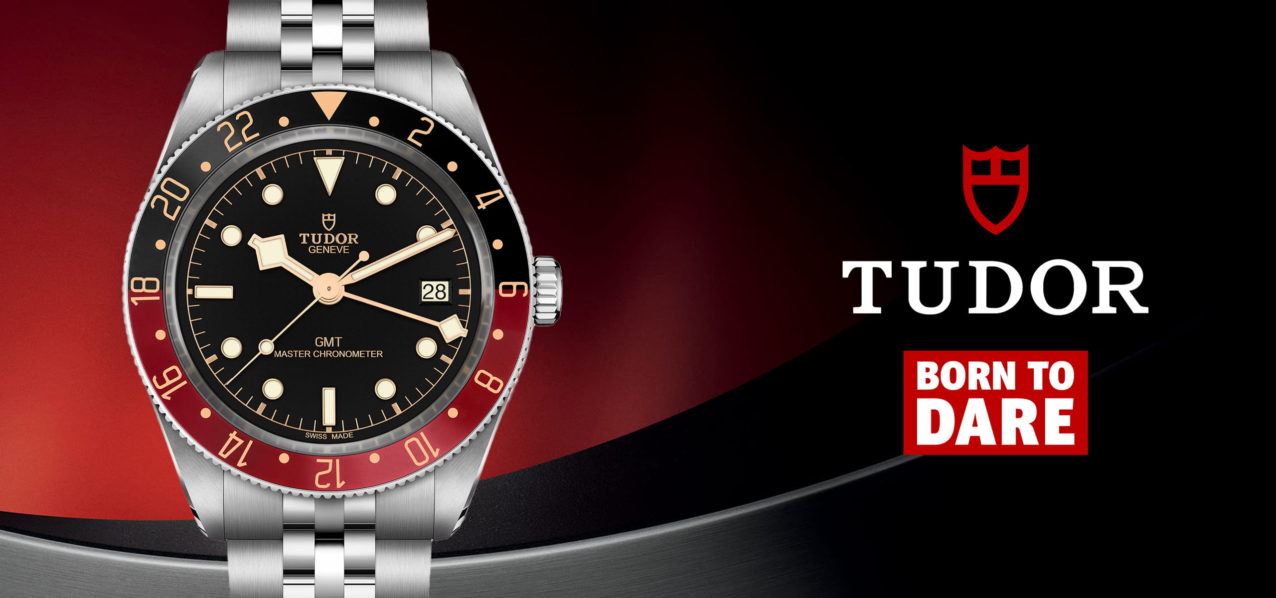 Eine Tudor GMT-Armbanduhr mit schwarzem Zifferblatt, rot-blauer Lünette und silbernem Armband wird auf einem rot-schwarzen Hintergrund neben dem markanten Tudor-Logo und dem Slogan Born to Dare" in auffälliger weiß-roter Schrift präsentiert.